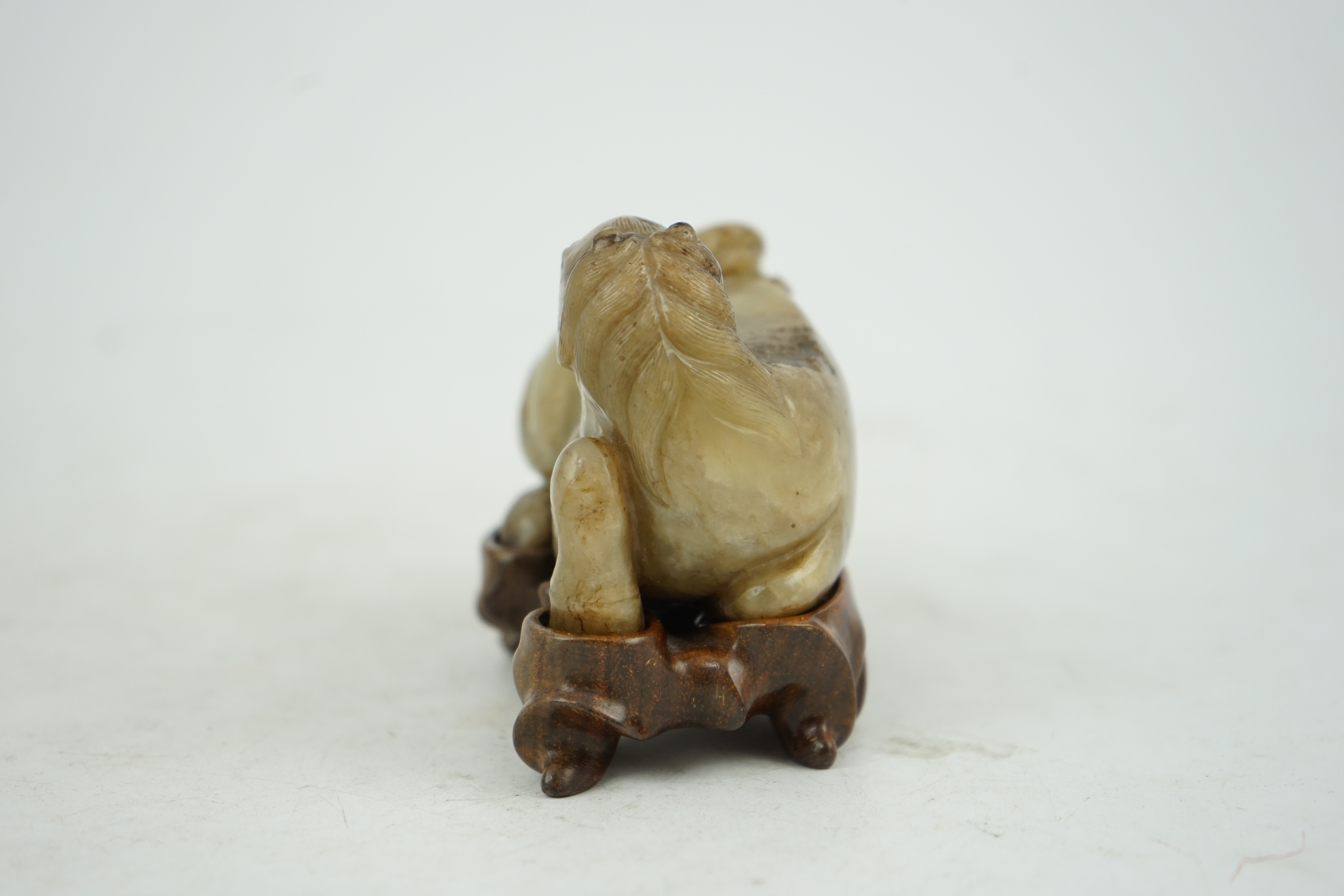 A Chinese celadon and mottled brown jade figure of a monkey climbing on a recumbent horse, Ming dynasty, 16th-17th century